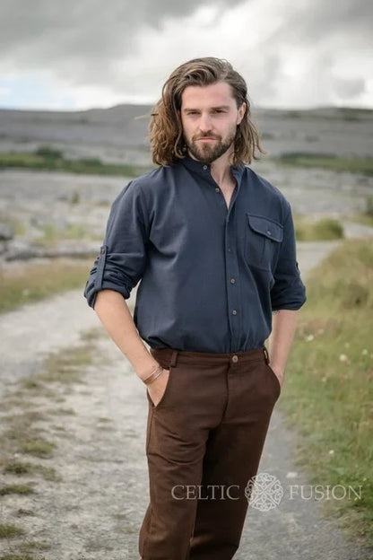 Celtic collarless dress shirt for men in midnight blue, styled outdoors as a button down shirt with rollable sleeves and a chest pocket