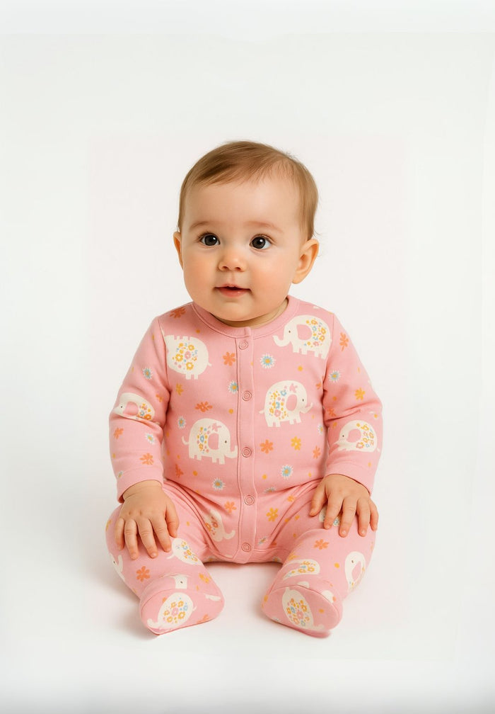 Detail of a pink long sleeve sleepsuit with elephant print and press stud fastening.