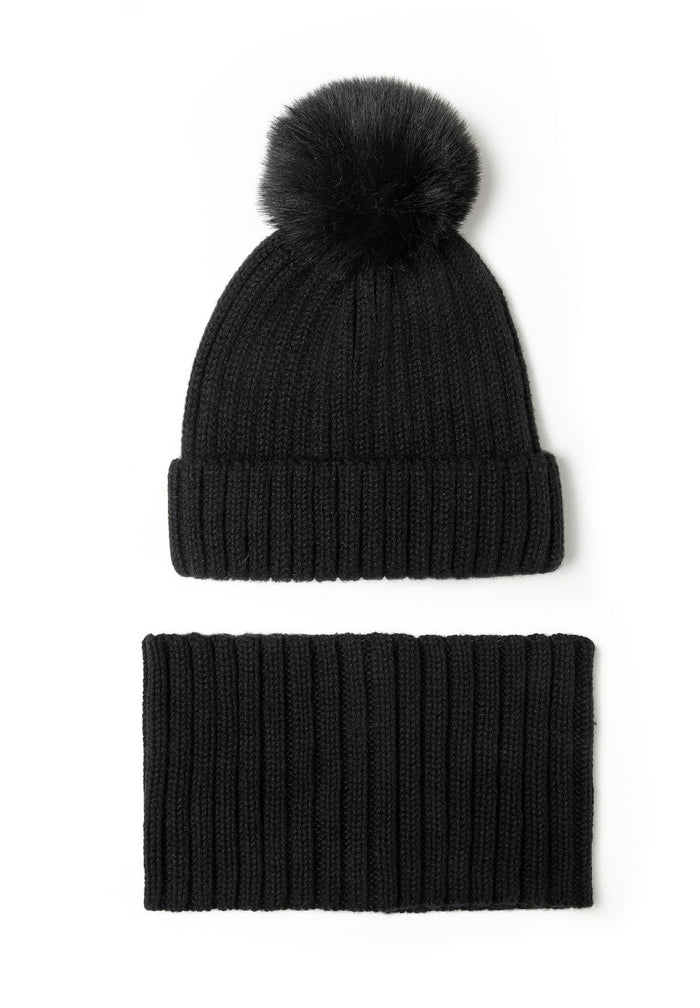 Black knitted beanie hat with faux fur pom pom and matching snood, front view.
