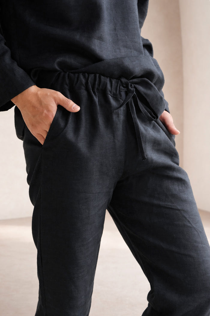 Person wearing black pants with a neutral background