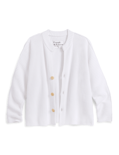 White cardigan with buttons on a black background