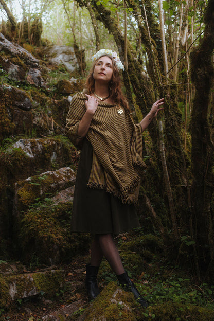 Handwoven wool blend shawl with fringe and brass oak leaf brooch, styled as a woodland shawl over a dark green folklore dress by Celtic Fusion