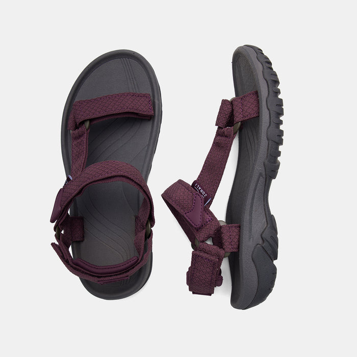 Pair of sandals with purple straps on a light gray background